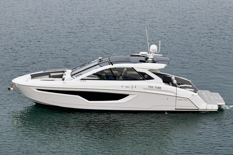 Slide: The Image of 2022 Cruisers 42 GLS yacht on calm water with modern waterfront homes in the background. - 12