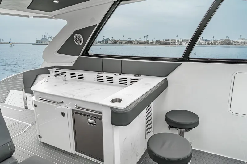 Slide: The Image of Luxurious seating area on 2022 Cruisers 42 GLS yacht, featuring sleek gray and white upholstery. - 26