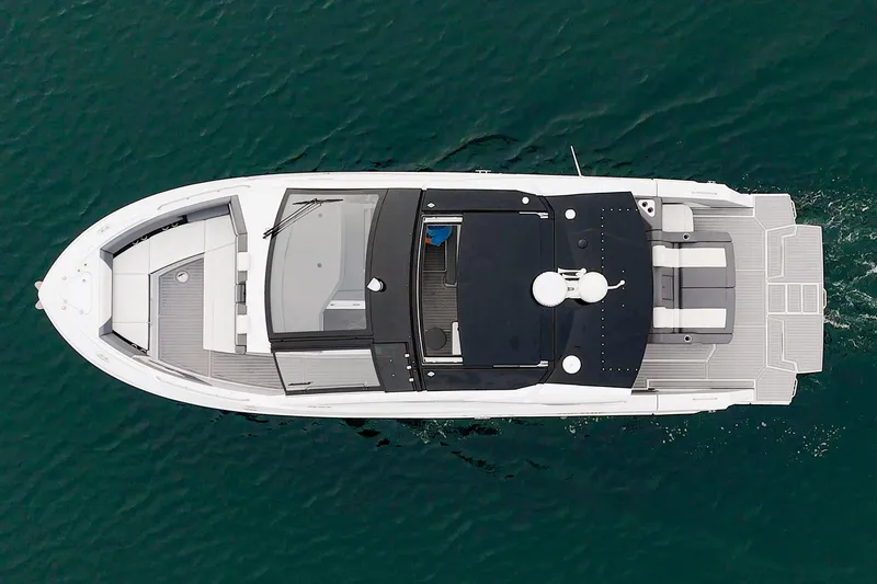 Slide: The Image of 2022 Cruisers 42 GLS luxury yacht with spacious deck and seating on water. - 7