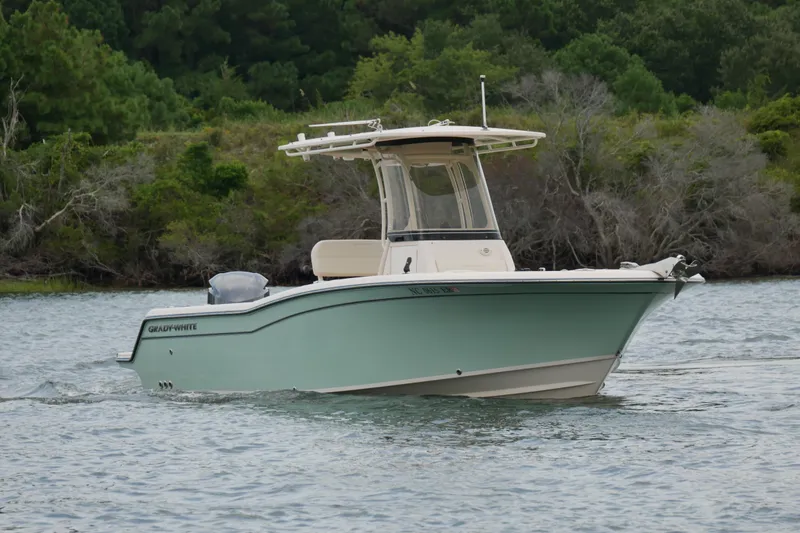 Slide: The Image of 2021 Grady-White Fisherman 236 boat cruising on a calm lake with lush greenery. - 4