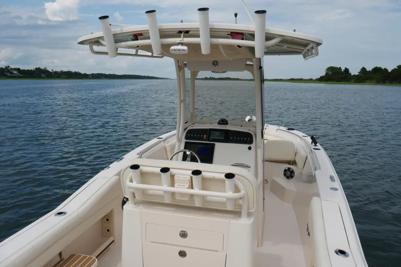 Slide: The Image of 2021 Grady-White Fisherman 236 boat on calm water, featuring a sleek console and rod holders. - 5