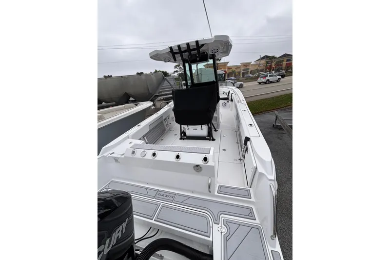 Slide: The Image of 2025 Blackfin 252 CC boat with sleek design and modern features, docked outdoors. - 7
