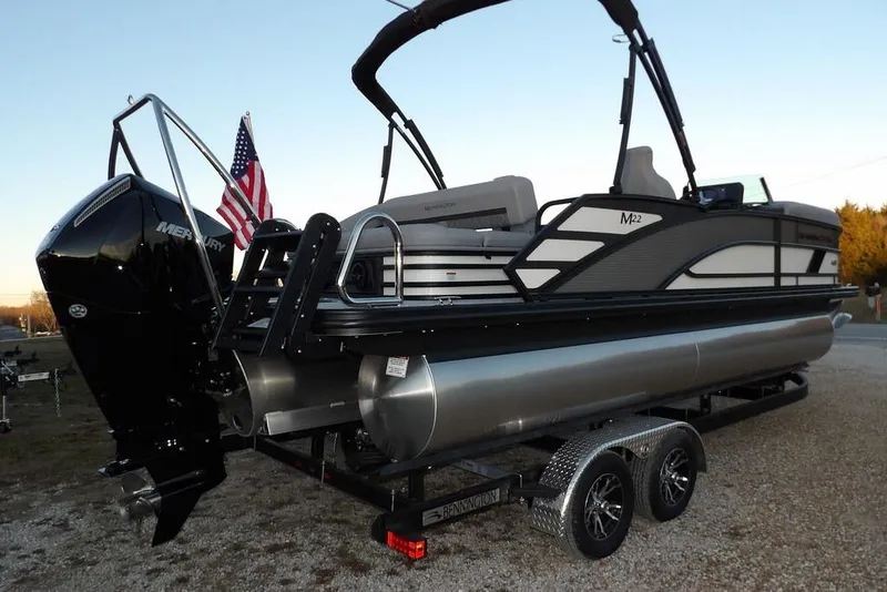Slide: The Image of 2026 Bennington M Swingback 22 MSB pontoon boat on trailer, featuring Mercury outboard motor. - 5