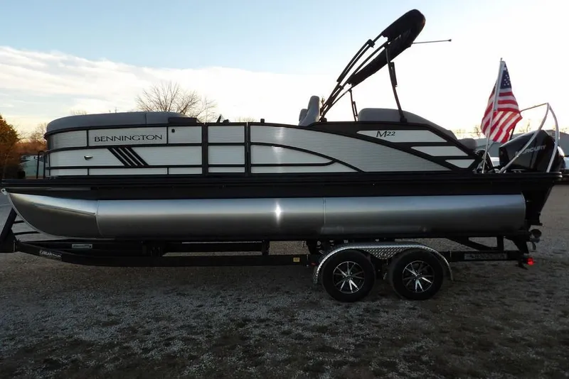 Slide: The Image of 2026 Bennington M Swingback 22 MSB pontoon boat on trailer with American flag. - 6