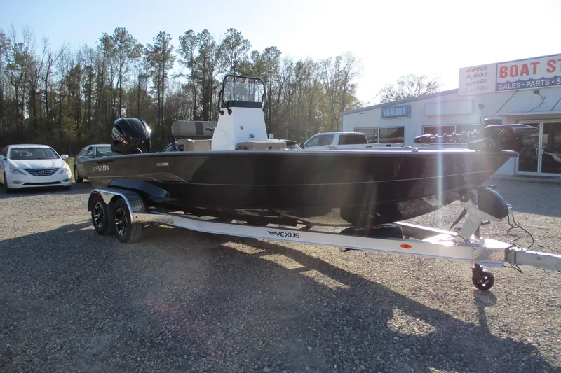 Slide: The Image of 2026 Vexus ACX2210 boat on trailer, parked outside a dealership. - 2