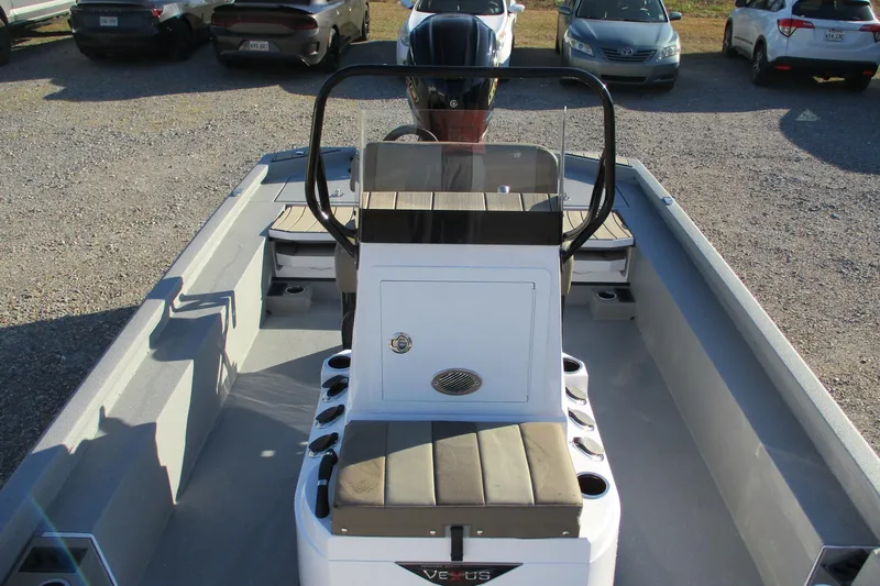 Slide: The Image of 2026 Vexus ACX2210 boat interior with seating and console, parked in a lot. - 9