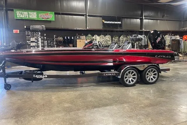 Slide: The Image of 2026 Caymas CX 21 PRO bass boat in showroom, red finish, on trailer. - 2