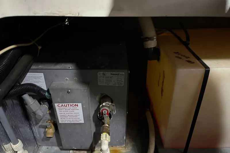 Slide: The Image of 1995 Carver 250 Express engine compartment with caution-labeled equipment and storage tank. - 30