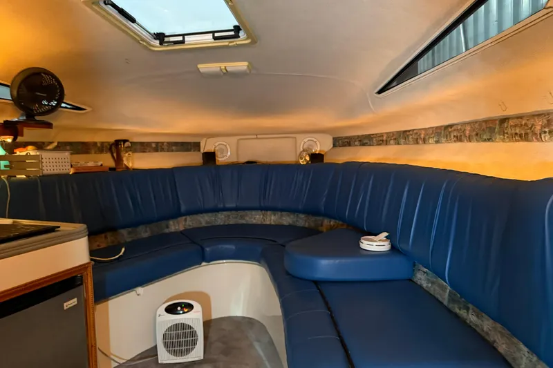 Slide: The Image of Interior of 1995 Carver 250 Express boat with blue seating and cozy cabin layout. - 8