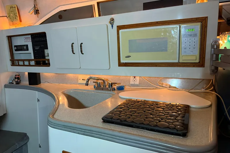 Slide: The Image of 1995 Carver 250 Express boat kitchen with sink, microwave, and countertop. - 14