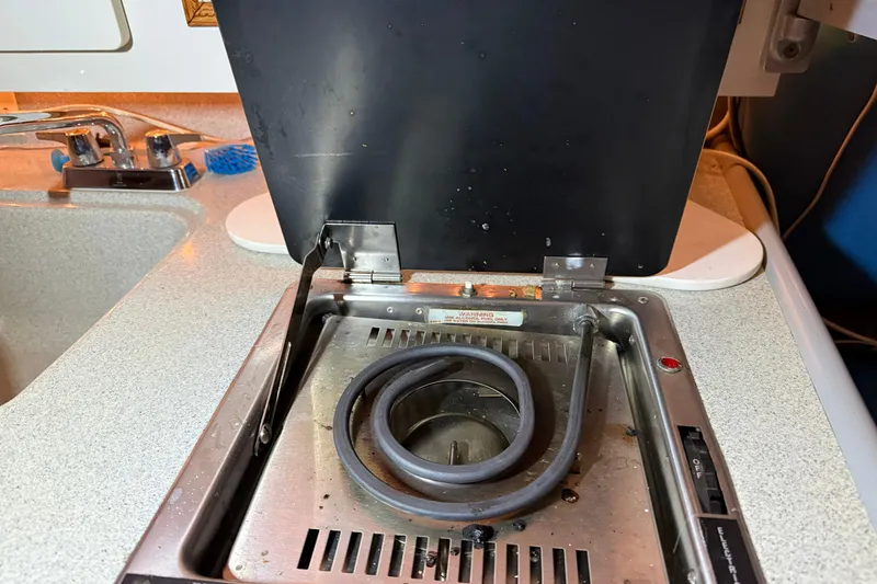 Slide: The Image of 1995 Carver 250 Express boat stove with open lid and coiled burner. - 15