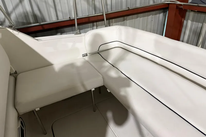 Slide: The Image of 1995 Carver 250 Express boat interior with white seating and metal railings. - 18