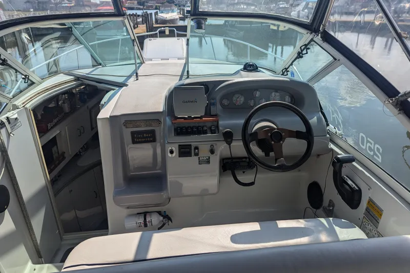 Slide: The Image of 1995 Carver 250 Express boat cockpit with steering wheel and Garmin navigation system. - 3