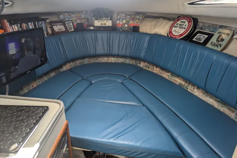 Slide: The Image of Interior of a 1995 Carver 250 Express boat with blue seating and a TV. - 6
