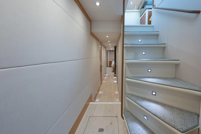 Slide: The Image of Luxurious interior of 2012 Lazzara Breeze yacht, featuring elegant hallway and illuminated staircase. - 14
