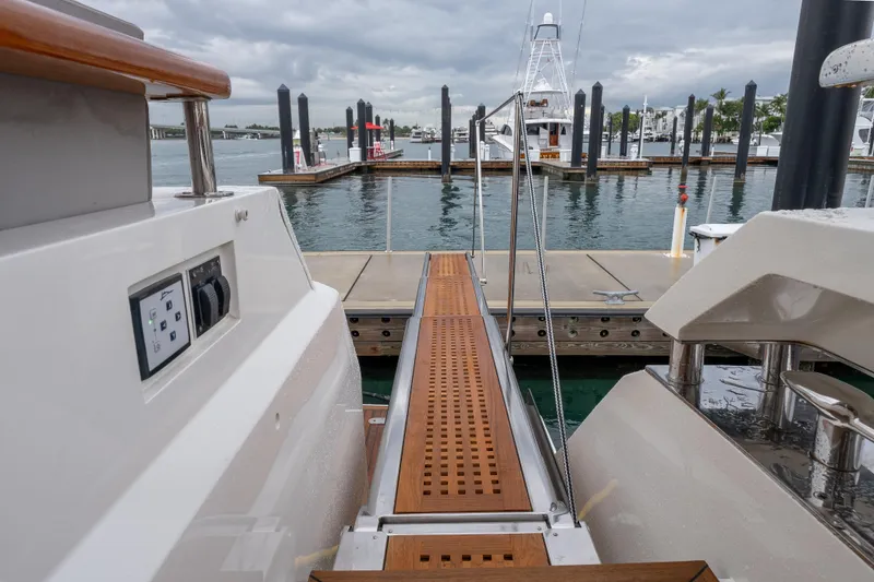 Slide: The Image of 2012 Lazzara Breeze yacht docked, featuring a wooden gangway and marina view. - 48