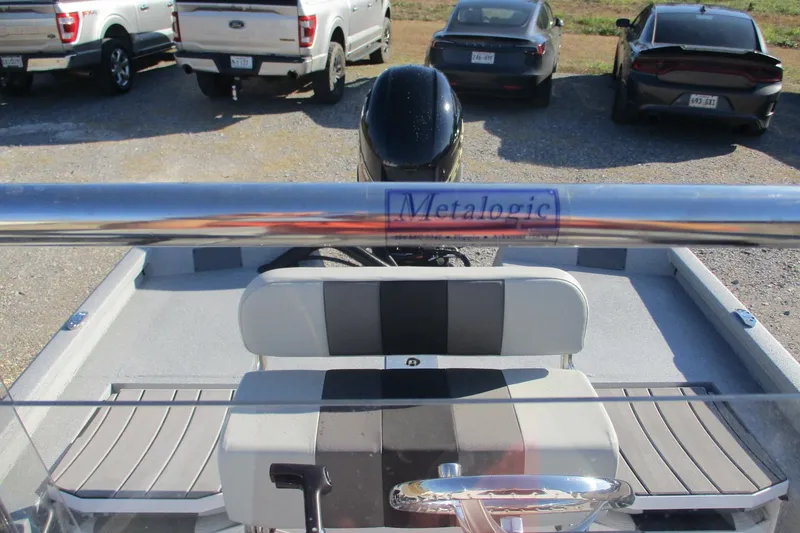 Slide: The Image of 2026 Vexus Defender 201 boat interior with steering wheel and seating, parked cars in background. - 10