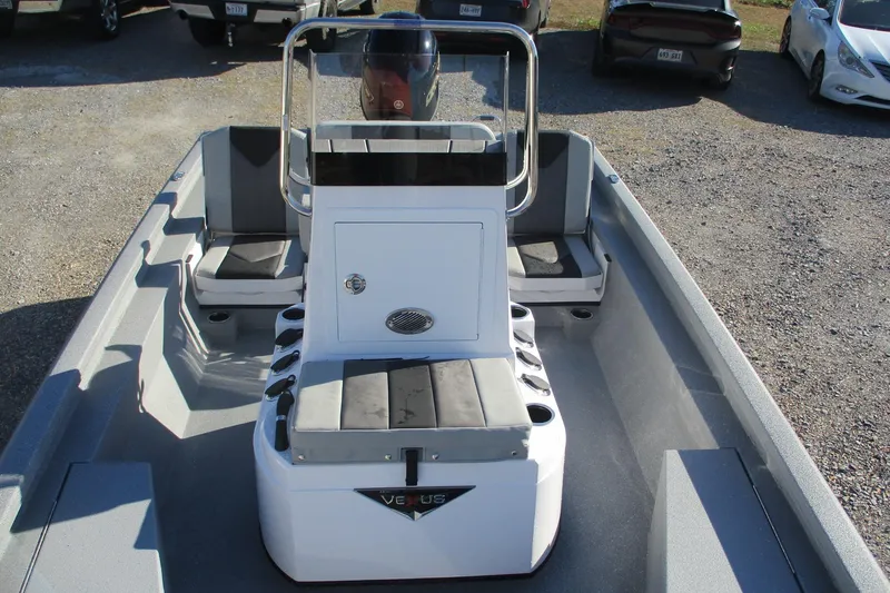 Slide: The Image of 2026 Vexus Defender 201 boat interior with seating and console, parked on gravel. - 13