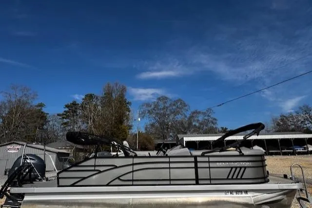 Slide: The Image of 2022 Bennington 23 LSB pontoon boat parked outdoors under a clear blue sky. - 2