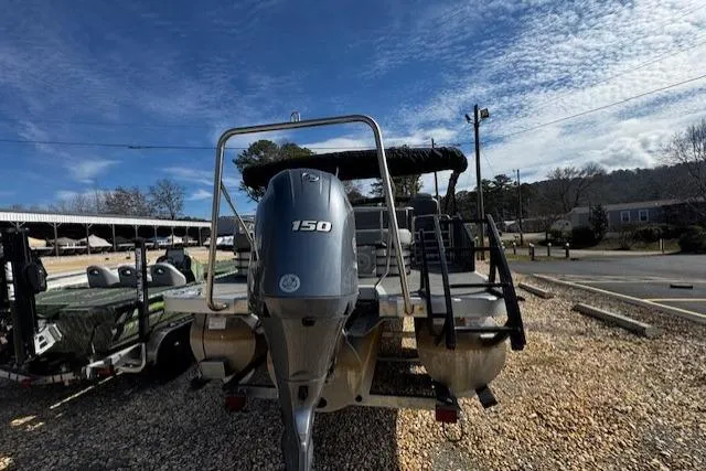Slide: The Image of 2022 Bennington 23 LSB pontoon boat with 150 HP engine, parked outdoors. - 9