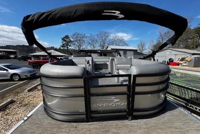 Slide: The Image of 2022 Bennington 23 LSB pontoon boat with canopy, docked under clear blue sky. - 1