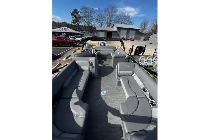 Slide: The Image of 2022 Bennington 23 LSB pontoon boat with spacious seating, parked outdoors. - 12