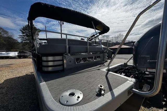 Slide: The Image of 2022 Bennington 23 LSB pontoon boat with sleek design and modern features, docked outdoors. - 13
