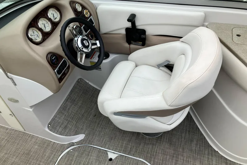 Slide: The Image of 2006 Four Winns 240 Horizon boat cockpit with steering wheel and white captain's chair. - 13