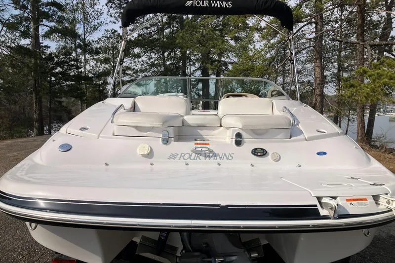 Slide: The Image of 2006 Four Winns 240 Horizon boat with white seating, docked near a forested lake. - 3