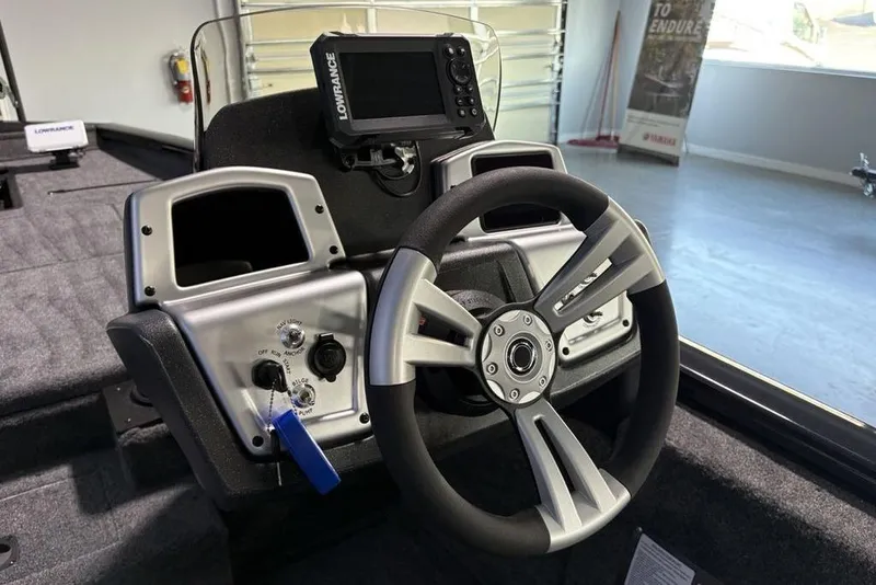 Slide: The Image of 2026 Tracker Pro Team 175 boat dashboard with steering wheel and Lowrance fishfinder. - 16