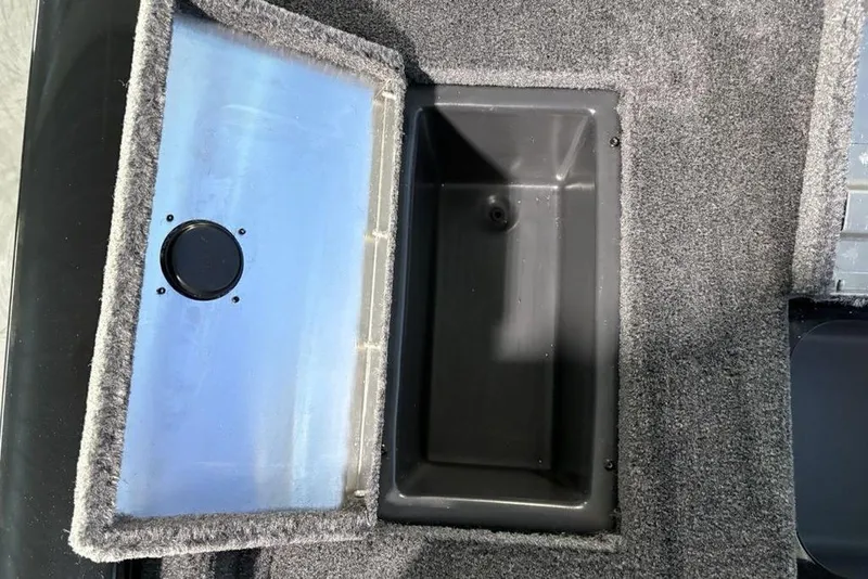 Slide: The Image of Open storage compartment in 2026 Tracker Pro Team 175 boat, featuring carpeted interior. - 25