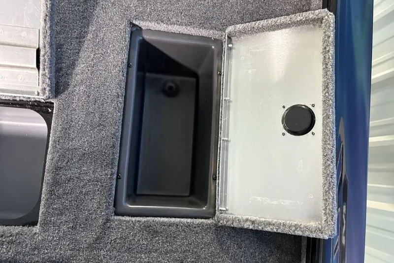 Slide: The Image of Open storage compartment in 2026 Tracker Pro Team 175 boat, featuring carpeted interior. - 26