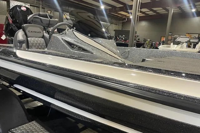Slide: The Image of 2026 Caymas CX 20 boat in showroom, featuring sleek design and modern seating. - 2