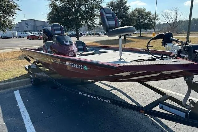 The Image of 2020 Ranger RT178 boat on trailer in parking lot, red color, two seats visible. - 1