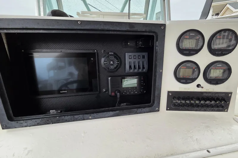 Slide: The Image of 1996 Regulator 26 Classic boat dashboard with Garmin display and Yamaha gauges. - 13