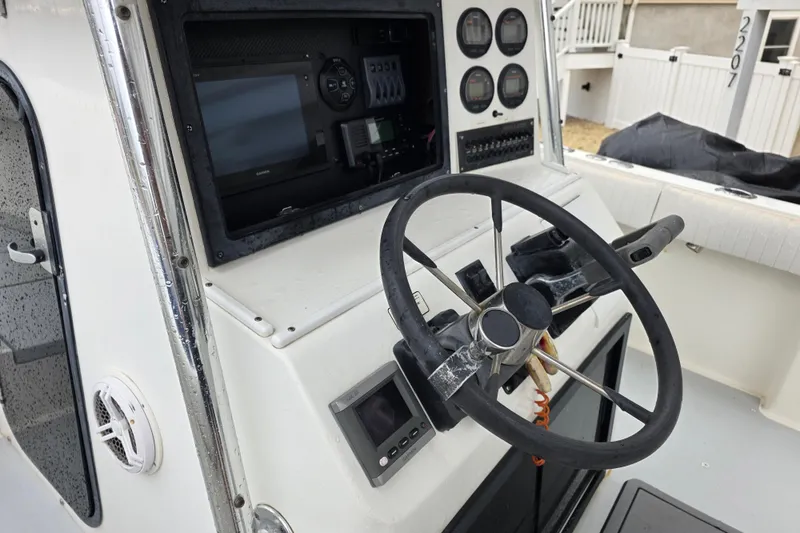 Slide: The Image of Steering console of a 1996 Regulator 26 Classic boat with gauges and controls. - 14