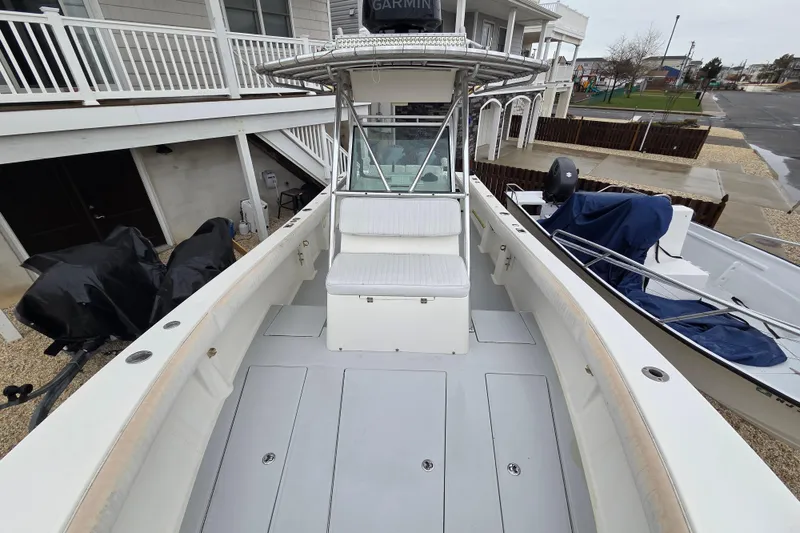 Slide: The Image of 1996 Regulator 26 Classic boat with spacious deck and seating, docked near a residential area. - 19