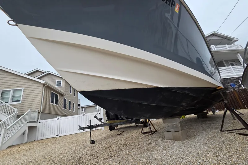 Slide: The Image of 1996 Regulator 26 Classic boat on stands, residential background. - 22