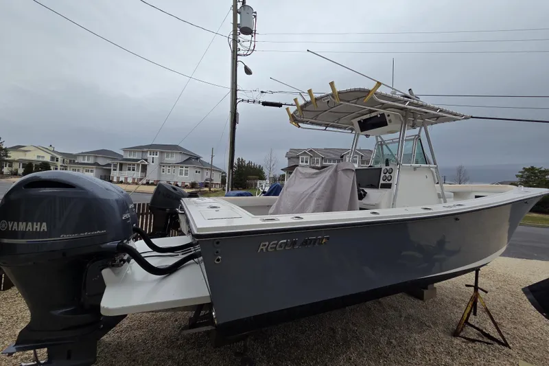 Slide: The Image of 1996 Regulator 26 Classic boat with Yamaha engine, parked in residential area. - 4