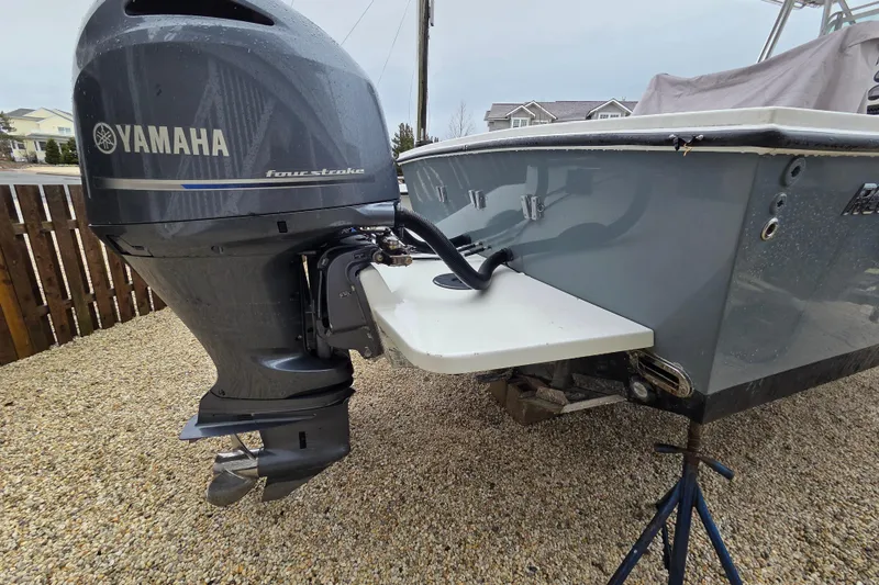 Slide: The Image of 1996 Regulator 26 Classic boat with Yamaha four-stroke outboard motor, parked on gravel. - 5