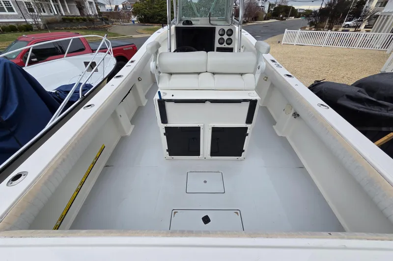 Slide: The Image of 1996 Regulator 26 Classic boat interior with seating and console, parked in a residential area. - 9
