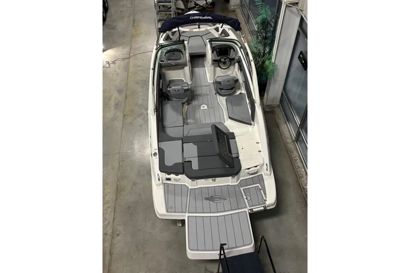 Slide: The Image of 2026 Chaparral 23 SSi boat interior, featuring sleek seating and modern design in showroom. - 11
