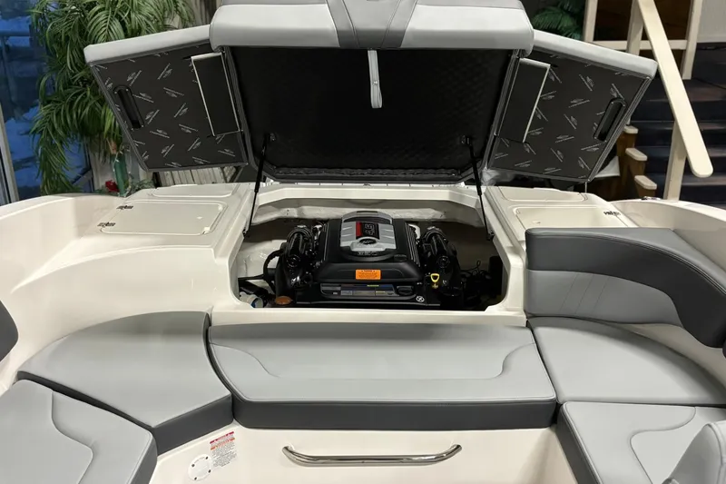 Slide: The Image of 2026 Chaparral 23 SSi boat engine compartment with open hatch and seating area. - 35
