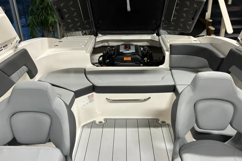Slide: The Image of 2026 Chaparral 23 SSi boat interior with open engine compartment and gray seating. - 36