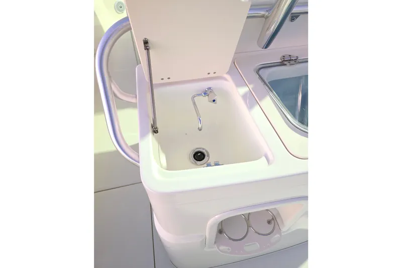 Slide: The Image of 2020 Mako 284 Center Console boat sink with open lid and faucet. - 19