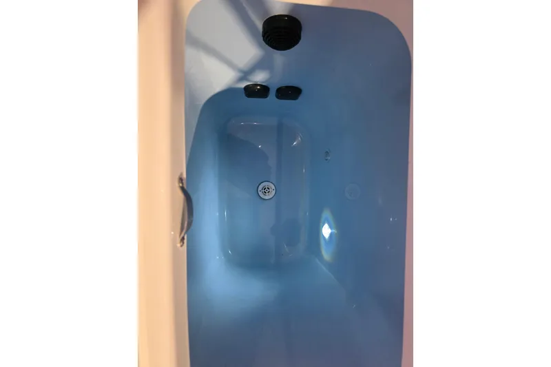 Slide: The Image of Blue bathtub interior with drain and handle, viewed from above. - 20