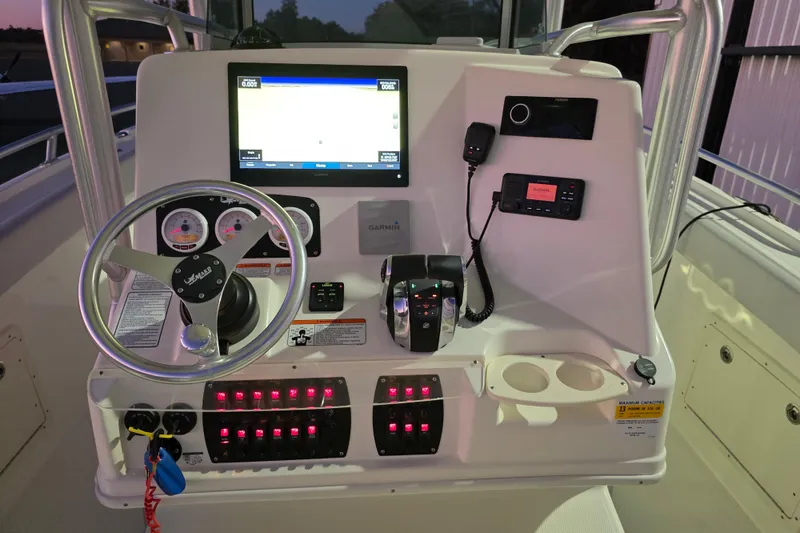 Slide: The Image of 2020 Mako 284 Center Console boat dashboard with steering wheel and navigation equipment. - 22