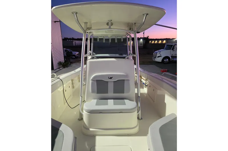 Slide: The Image of 2020 Mako 284 Center Console boat interior at sunset, featuring seating and console. - 24