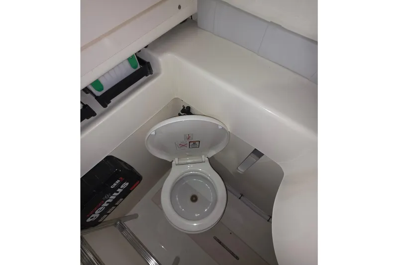 Slide: The Image of 2020 Mako 284 Center Console boat interior with toilet and storage area. - 30