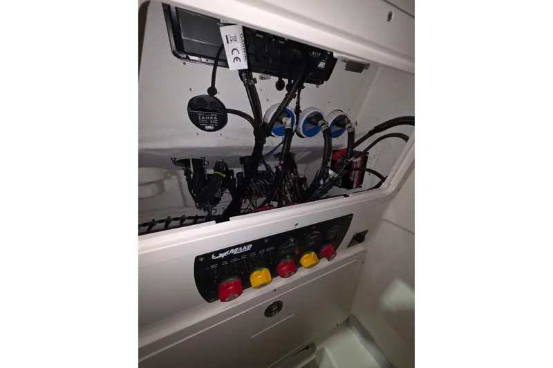 Slide: The Image of Electrical panel inside a 2020 Mako 284 Center Console boat, showcasing wiring and controls. - 31